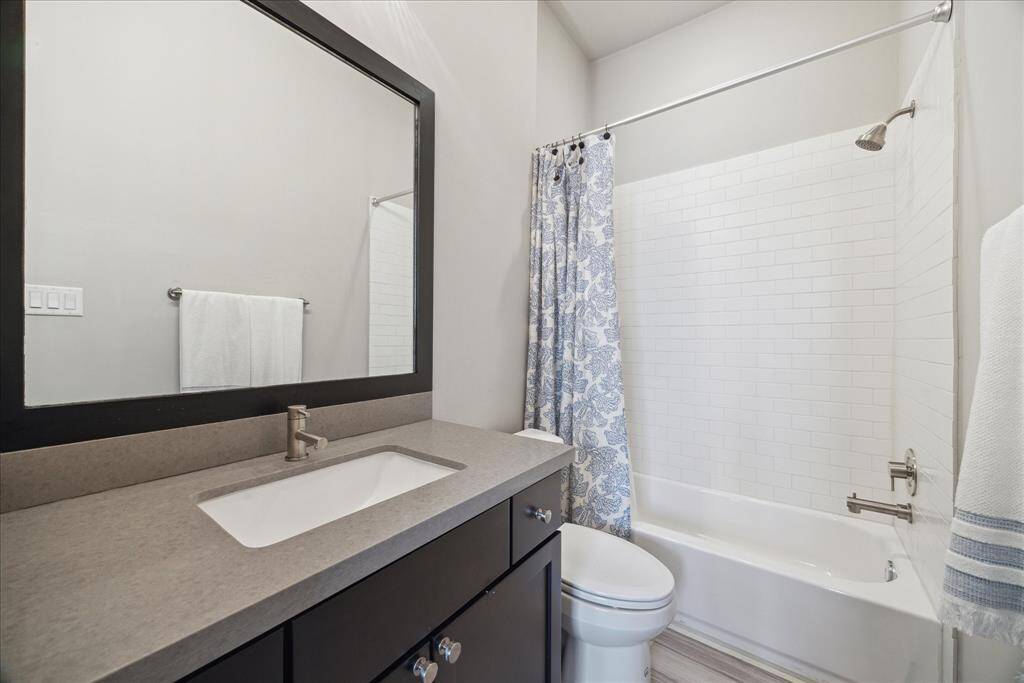 The top-floor en suite secondary bathroom provides a tub/shower and a wide vanity with a quartz counter.