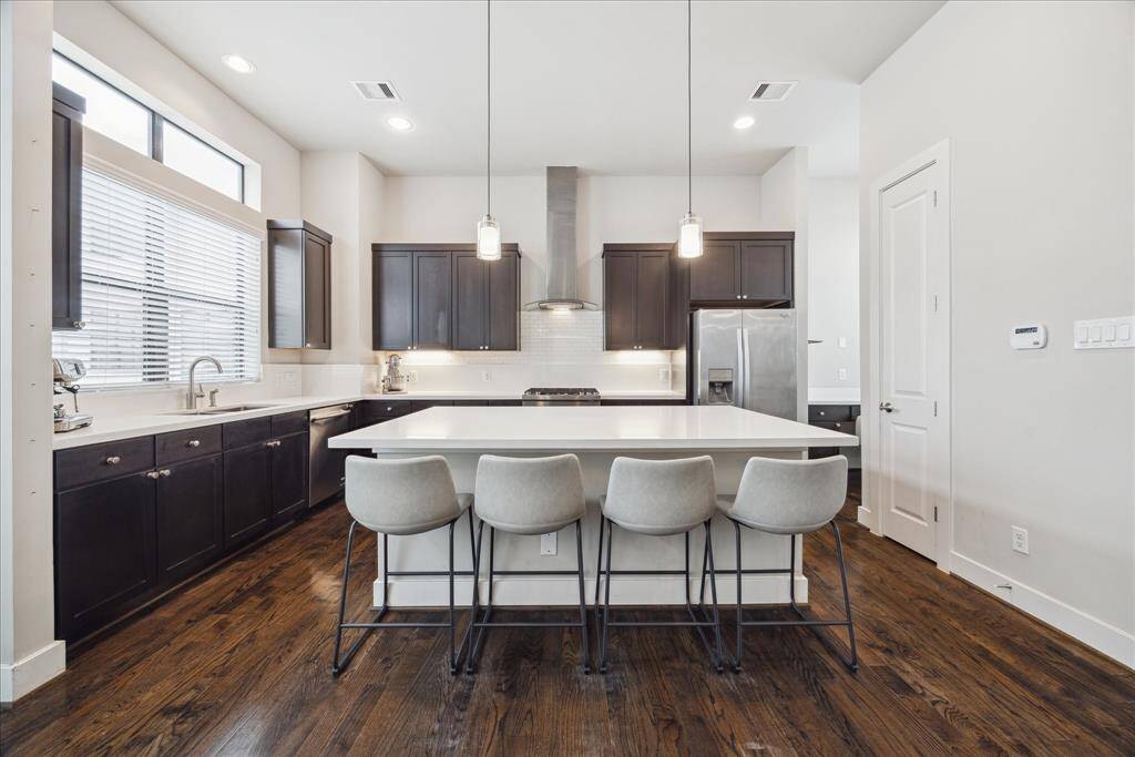 This beautifully designed open gourmet kitchen impresses with custom soft-close cabinetry, generous quartz countertops, under-cabinet lighting and brushed nickel hardware. An adjacent pantry adds plenty of additional storage.
