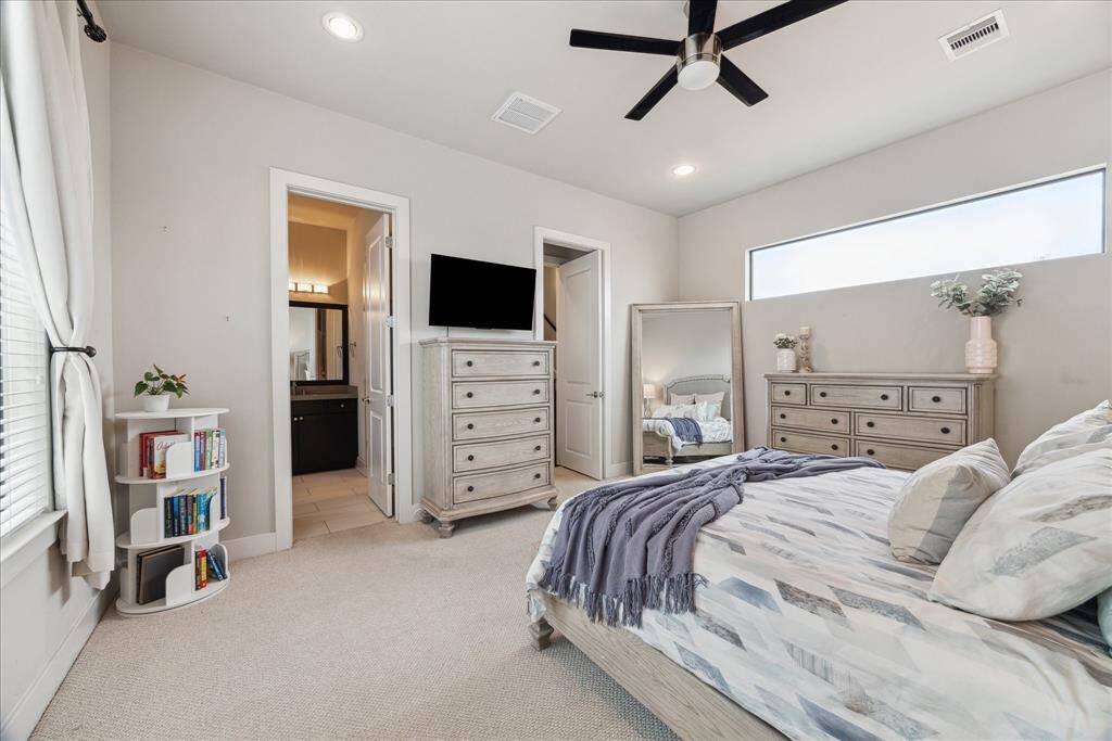The spacious primary bedroom offers plenty of space for a seating area and additional furniture, plus a custom walk-in closet and an en suite spa bathroom.