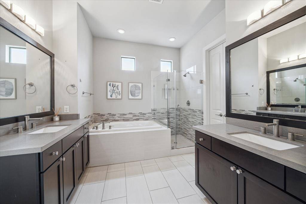 Perfect for busy mornings, the en suite primary bathroom is equipped with two separate vanities with generous cabinet space and quartz counters, an oversized soaking tub, a glass shower and a private water closet with a headknocker cabinet.