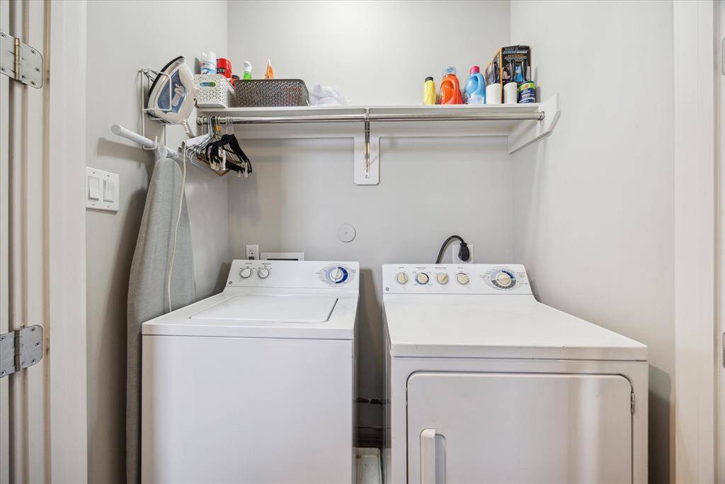 Laundry day is easy thanks to this top-floor utility room equipped with a side-by-side washer-dryer, gas and electric connections, and a storage shelf.