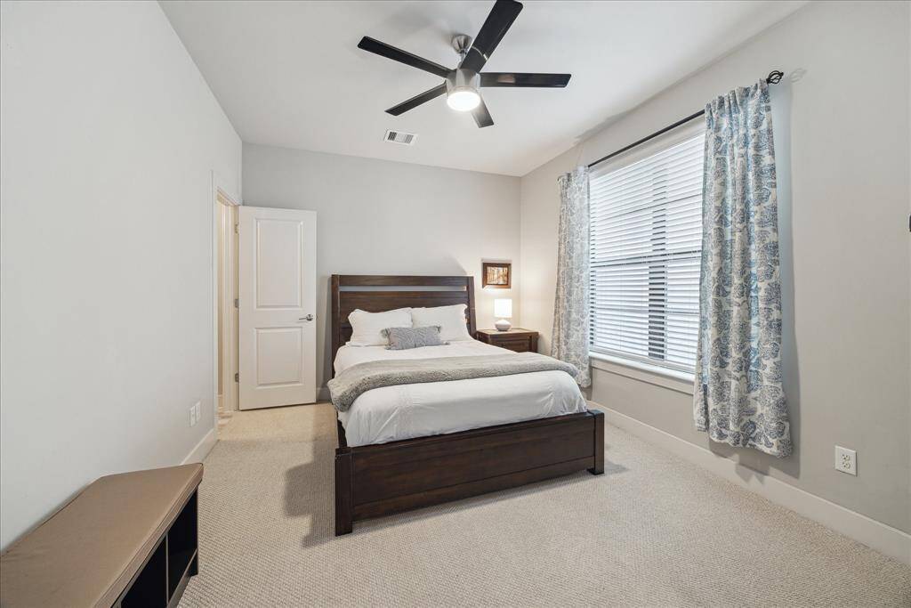 This ground-floor secondary suite boasts wall-to-wall carpeting, a lovely ceiling fan, a reach-in closet and an en suite bathroom.