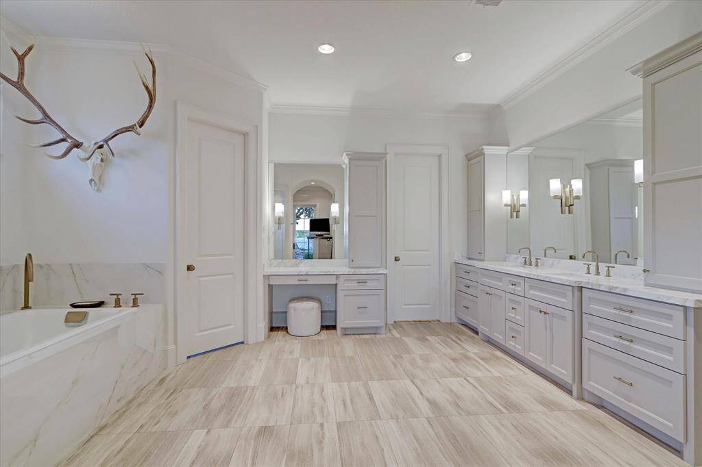 The primary bath offers a spa-like retreat with double sinks, abundant storage, and a luxurious soaking tub.