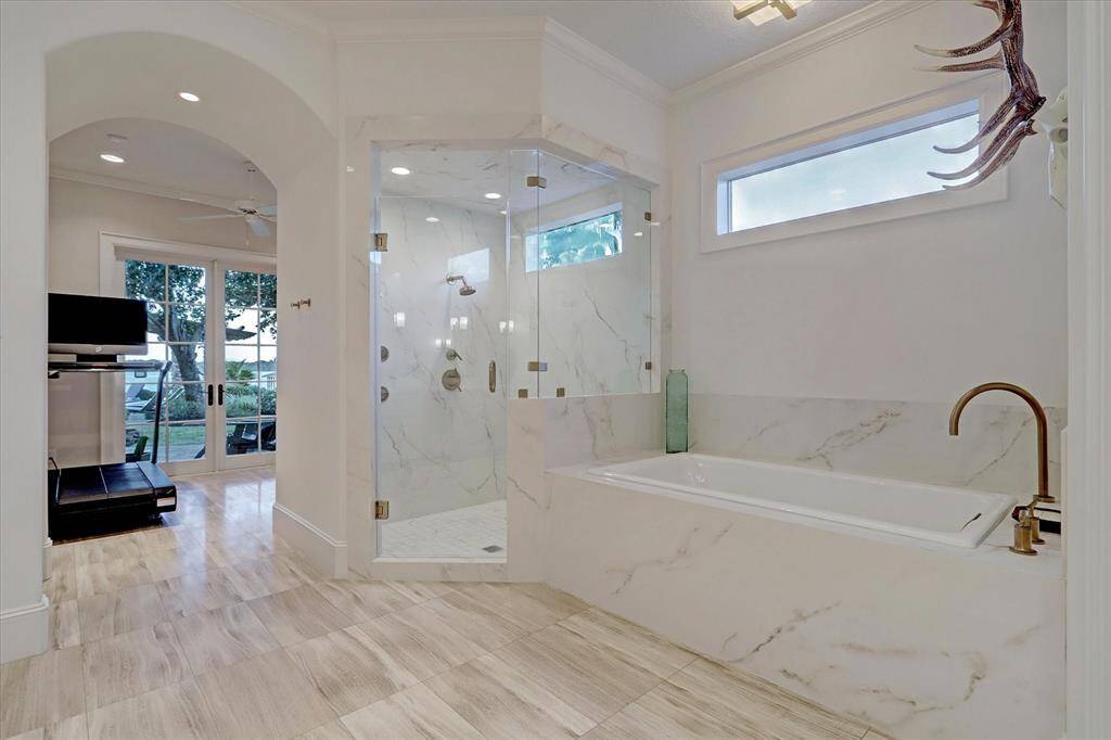 The primary suite includes a spacious walk-in shower and a private gym or yoga room with peaceful lake views.