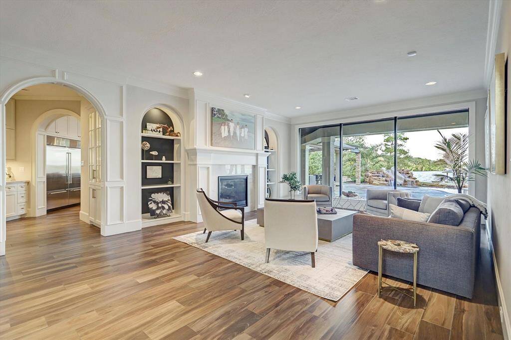 Formal living with a cozy fireplace and stunning views of the pool and lake beyond.