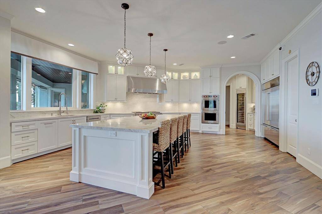Seamless flow into a chef's dream kitchen, featuring a massive Quartzite island and spacious walk-in pantry