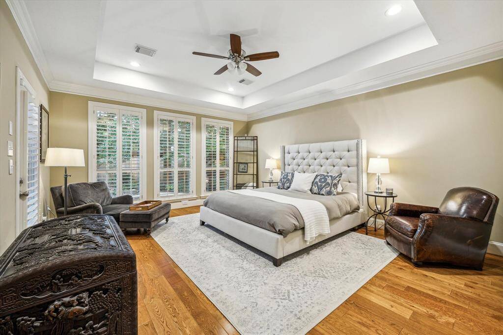 The primary suite is nothing short of a proper retreat with plentiful windows, plantation shutters, crown molding and well-maintained hardwood floors.