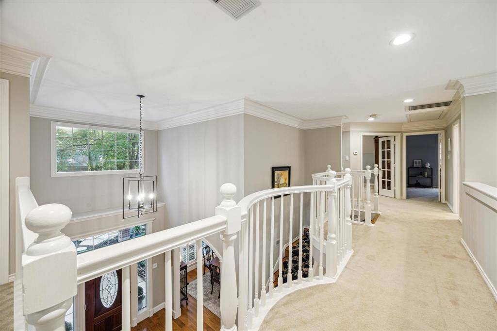 Elegance is embodied in every detail in the home from the curved white railing to the crown molding and the custom lighting.