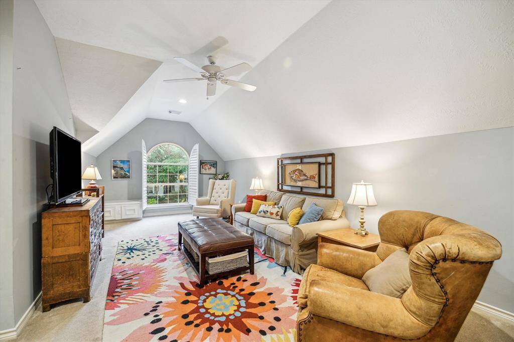 The pitched ceiling perfectly design custom plantation shutters define the space of this bonus family room creating both charm and whimsy.