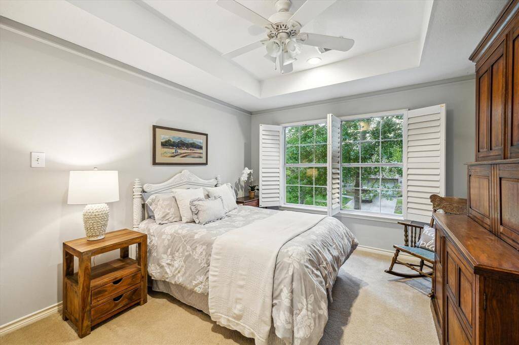 A secondary bedroom feels both large and cozy with tall ceilings and big windows that connect the indoor and outdoor spaces.