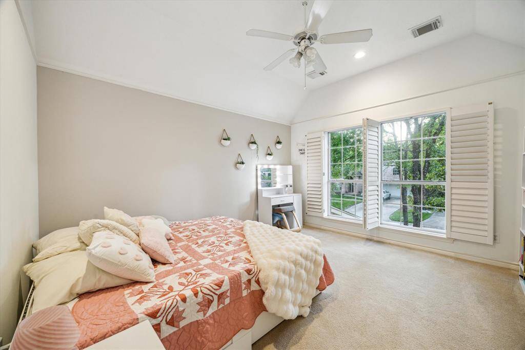 Large windows with plantation shutters in the upstairs bedrooms offer both privacy and a connection with nature.