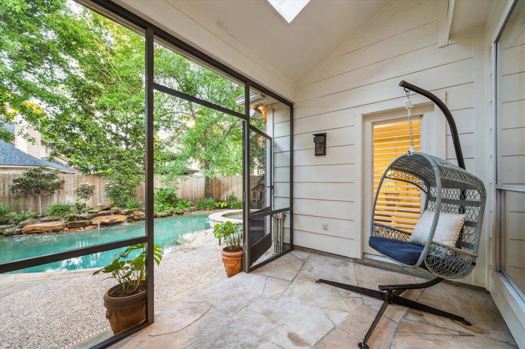 Escape the hot Texas summer in this indoor-outdoor screened porch with a view of the pool.