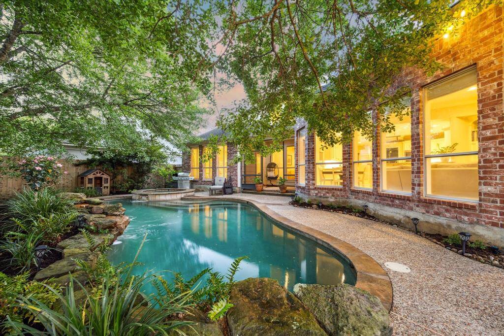 No detail is spared in the backyard oasis from the crystal clear pool to the lush surroundings.