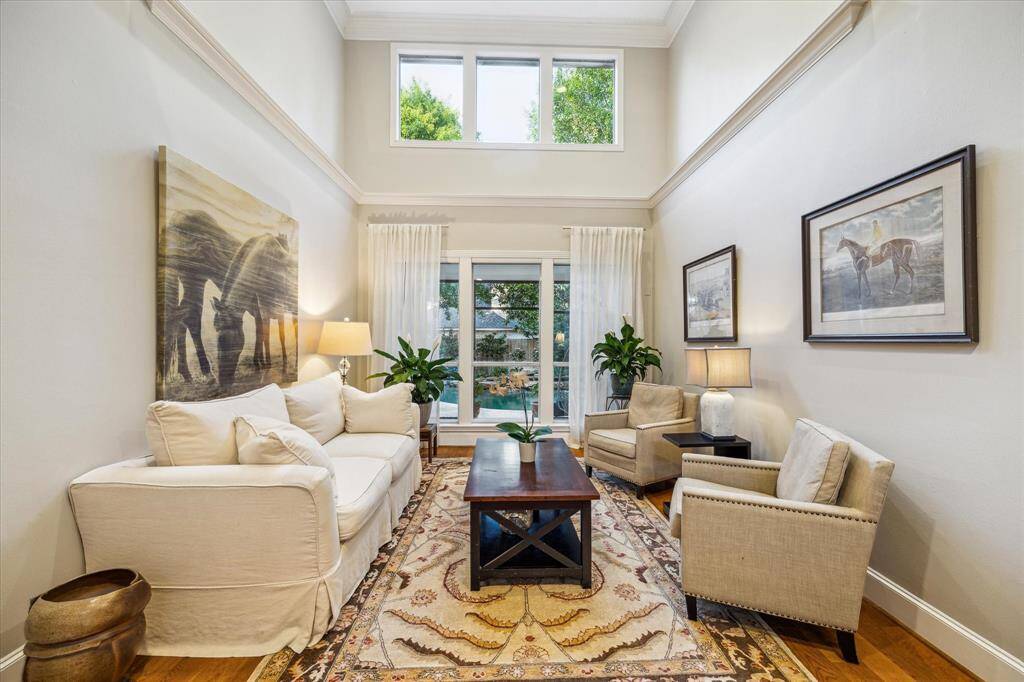 Tall ceilings and generous windows bring in the outdoor natural light and offer views of the lush green landscaping.