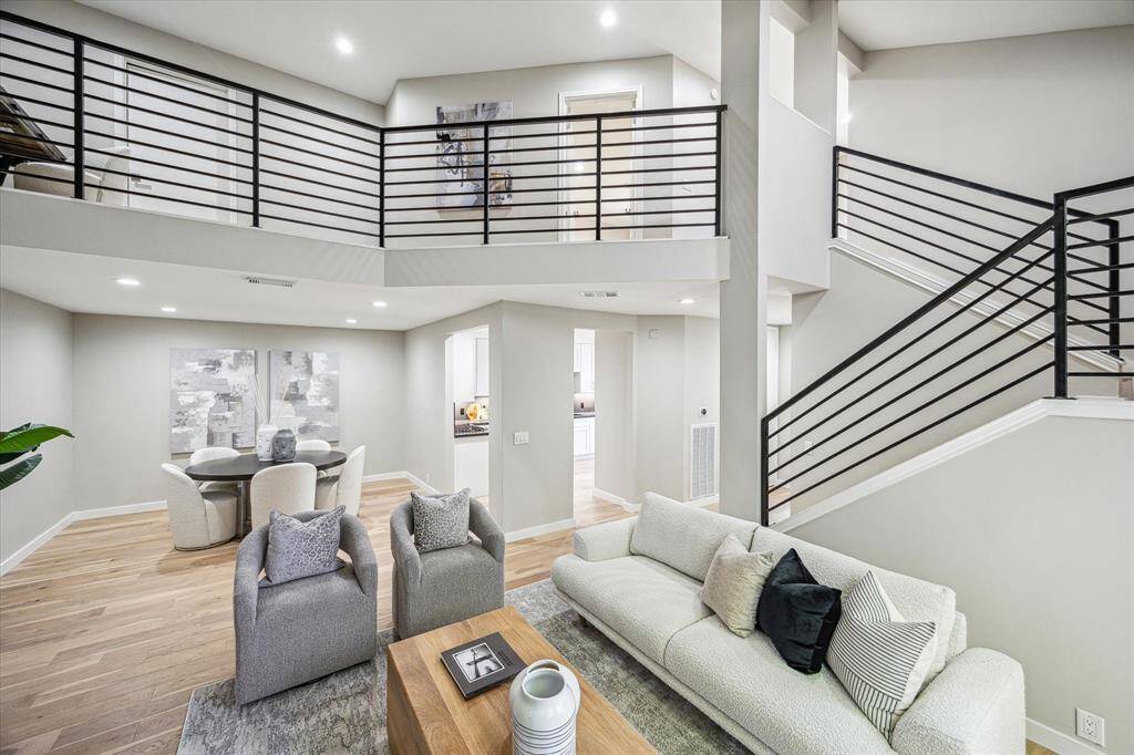 A floor-to-ceiling marble surround makes the fireplace a striking focal point in this modern urban retreat, where soaring ceilings, a natural color palette, and rich White Oak engineered wood flooring create a warm and inviting atmosphere.
