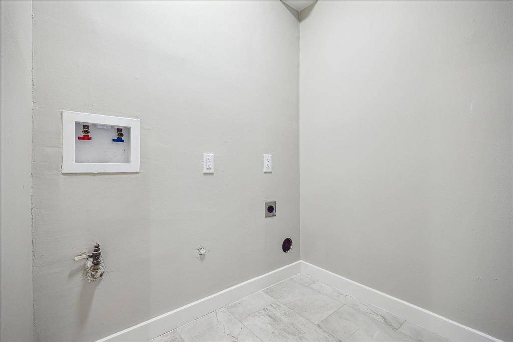 Conveniently located on the second floor near the bedrooms, the utility room features tile flooring, neutral paint, washer connections, and both gas and electric dryer hookups.