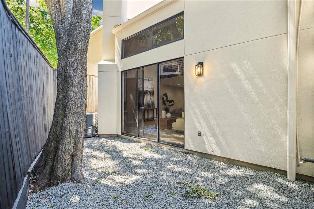 Sliding glass doors in the living room open to reveal a spacious gravel patio with a privacy fence and ample space for your personal touches.