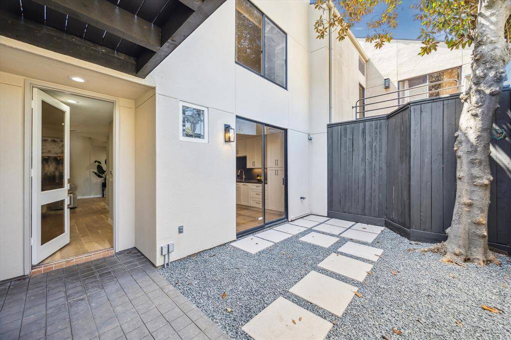 Blurring the lines between indoor and outdoor living, a wall of oversized glass doors in the living room invites the outdoors in, bathing the space in natural light and offering easy access to one of the home’s private patios.
