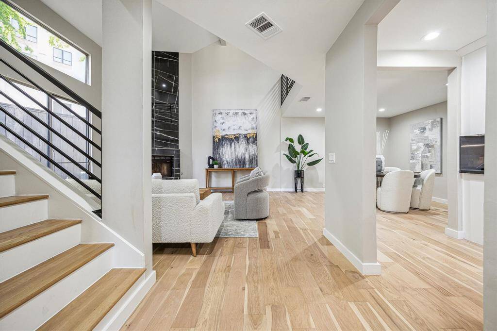 A gated courtyard entry welcomes you with a glass front door, sliding glass doors from the kitchen, and a tall privacy fence creating an inviting space to gather. With two ground-floor fenced patio areas and a second-floor balcony, this home offers multiple options for relaxed and connected outdoor living.