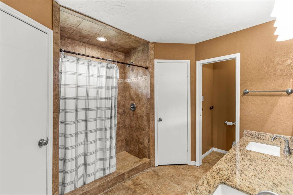 The master bedroom with updated walk-in shower and vanity with updated square drop-in sinks, granite counter tops and faucets