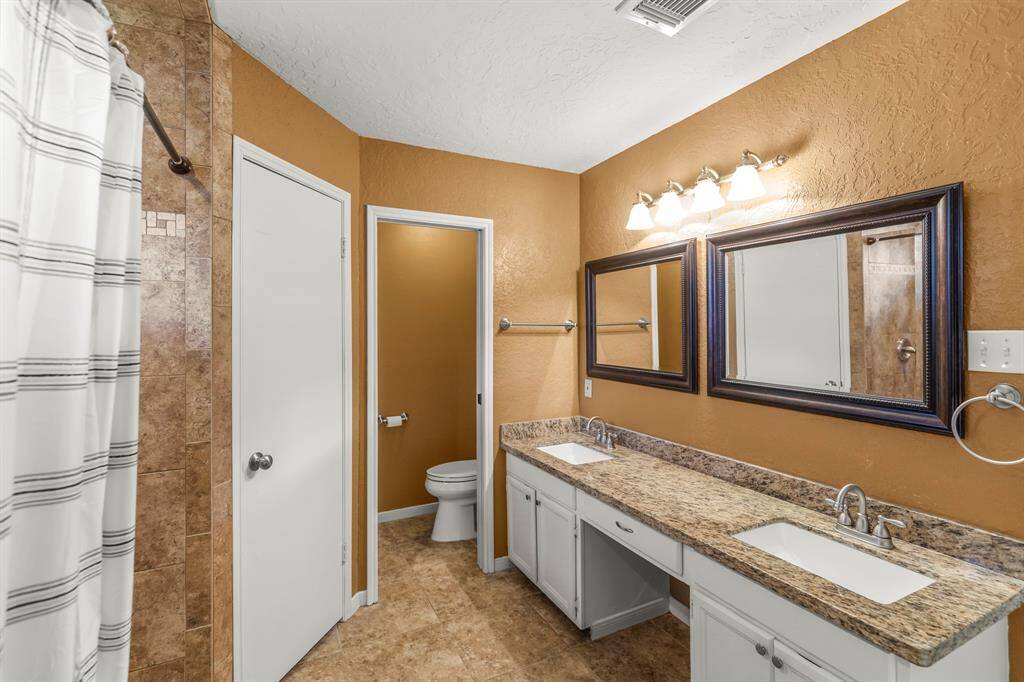 The master vanity is HUGE and has granite counter tops, updated rectangular drop in sinks and faucets, as well as framed mirrors and updated lighting.
