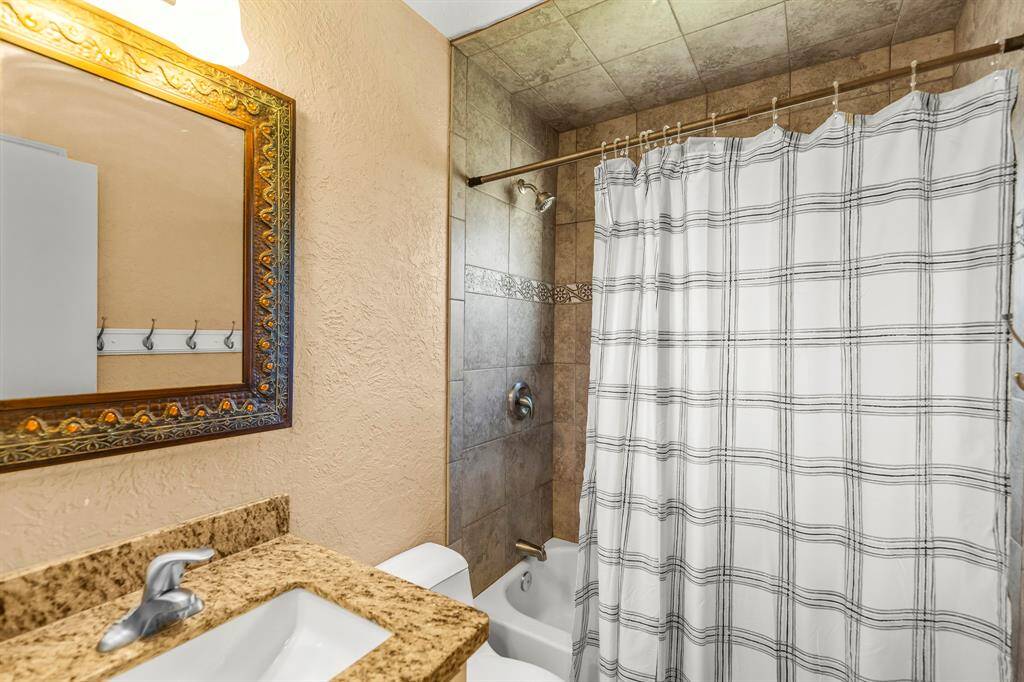 The secondary bathroom also has an updated vanity with rectangular drop in sink, granite counter tops and updated faucet.  The tub/shower has been updated with tile and faucet