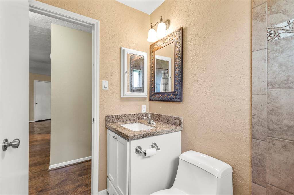 Another view of the secondary bathroom with custom vanity and lower drawer, granite counter tops, updated faucet, mirror, lighting and medicine cabinet