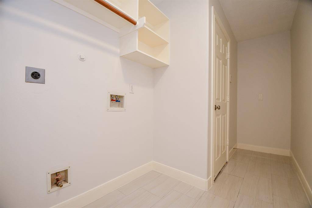 Laundry room has build in shelving and plenty of space for your choice of appliances
