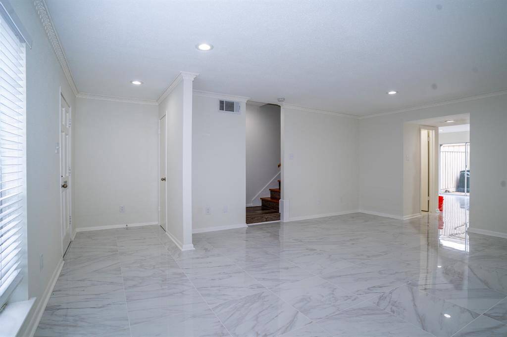 Living room showing front door on the left and stairway to the second floor.
