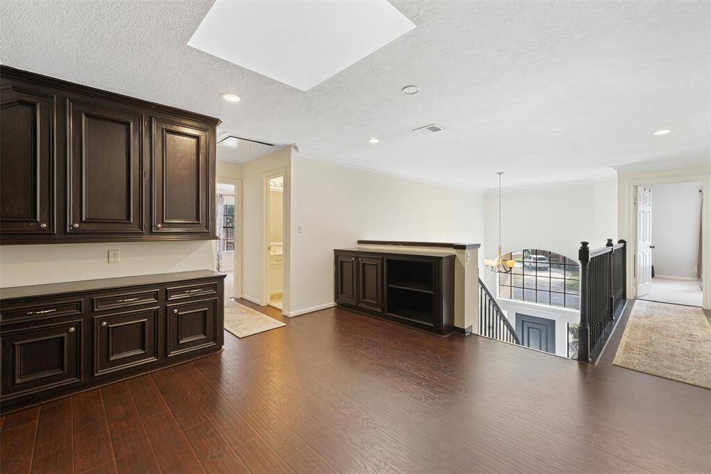 This open loft area includes built-in cabinetry, wood floors, and a view over the entry—ideal for a second living area or study nook.