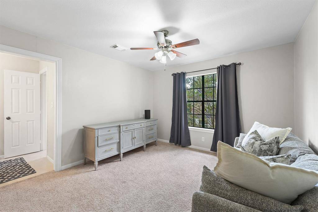 A versatile upstairs space with plush carpet and natural light—perfect as a secondary bedroom, media room, home office, or playroom.