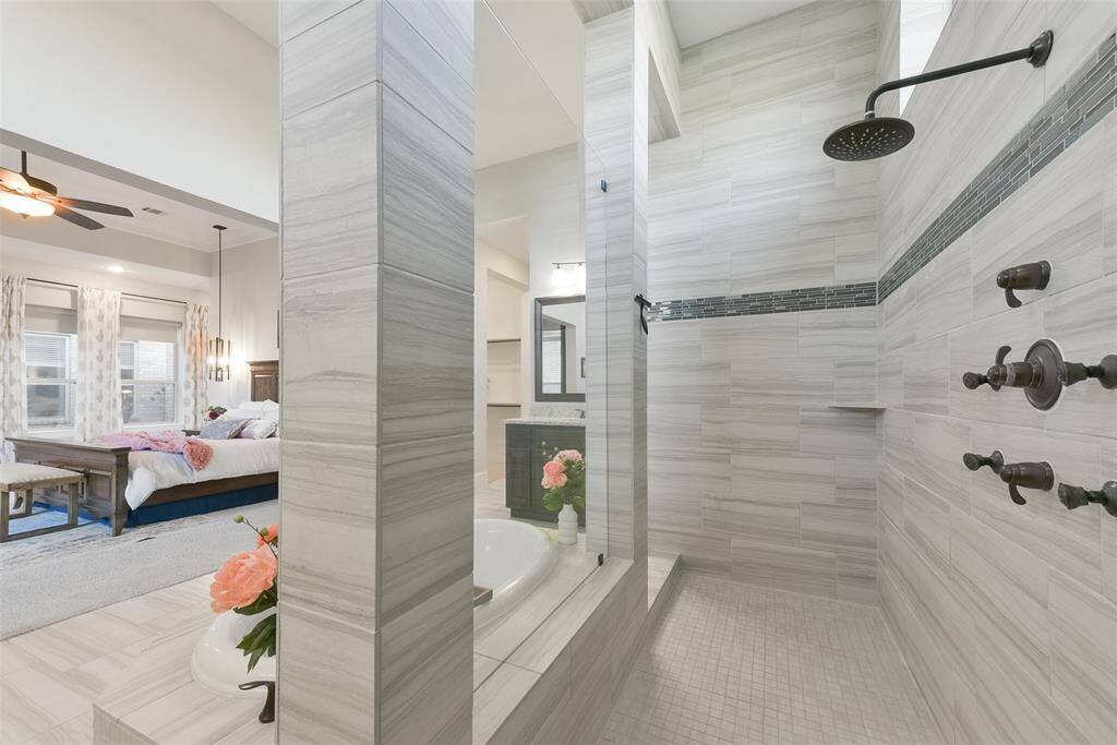 Rain showerhead and body sprayers in the shower.