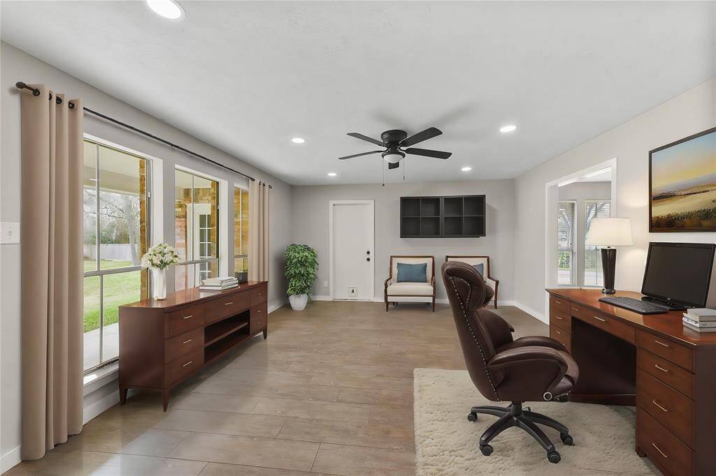 Just off of the breakfast room, find a flex use space that's perfect for a game room or home office! Notice the tile flooring, modern lighted ceiling fan, recessed lights, and wall to wall windows overlooking the backyard acreage with frequent wildlife visitors.