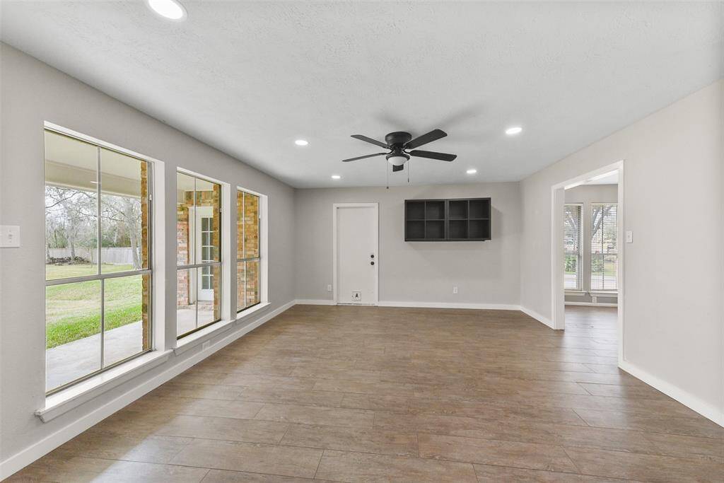 Just off of the breakfast room, find a flex use space that's perfect for a game room or home office! Notice the tile flooring, modern lighted ceiling fan, recessed lights, and wall to wall windows overlooking the backyard acreage with frequent wildlife visitors.