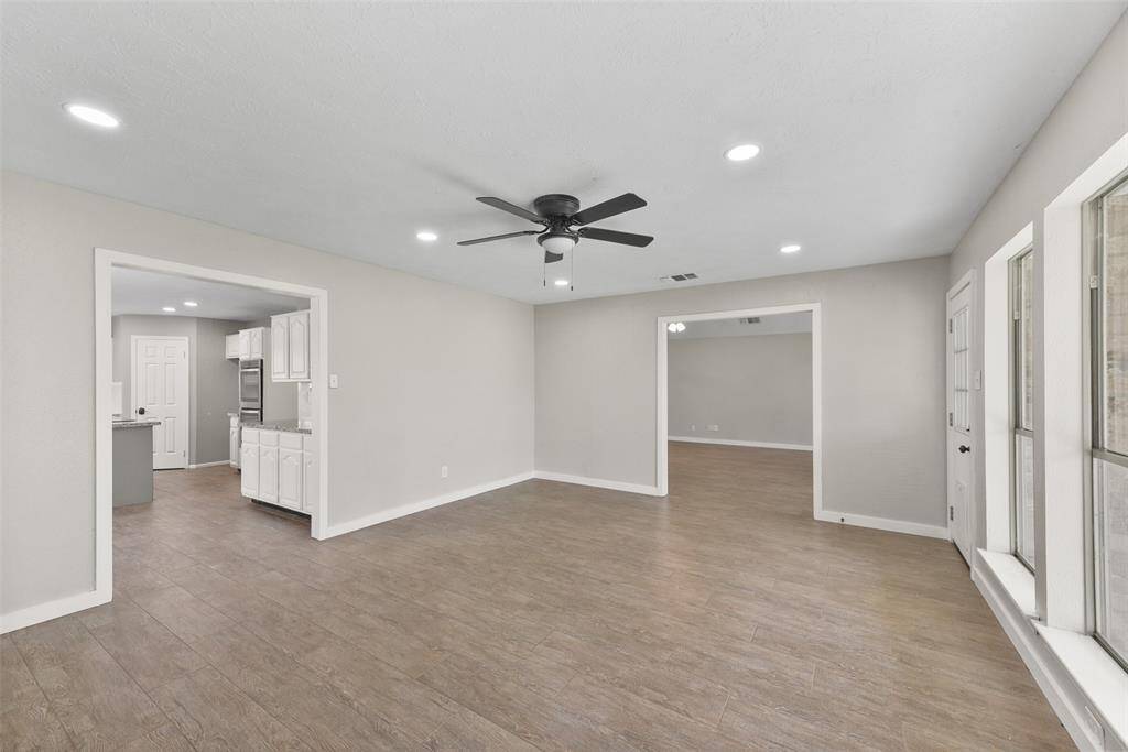Just off of the breakfast room, find a flex use space that's perfect for a game room or home office! Notice the tile flooring, modern lighted ceiling fan, recessed lights, and wall to wall windows overlooking the backyard acreage with frequent wildlife visitors.
