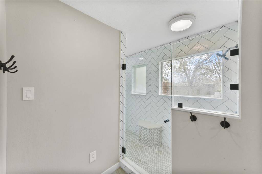 The master shower is a sight to behold, boasting a seamless glass door and detailed tilework throughout the impressively sized shower with a built-in bench seat and dual shower heads - one is a rainhead shower & the other is a removable shower head.