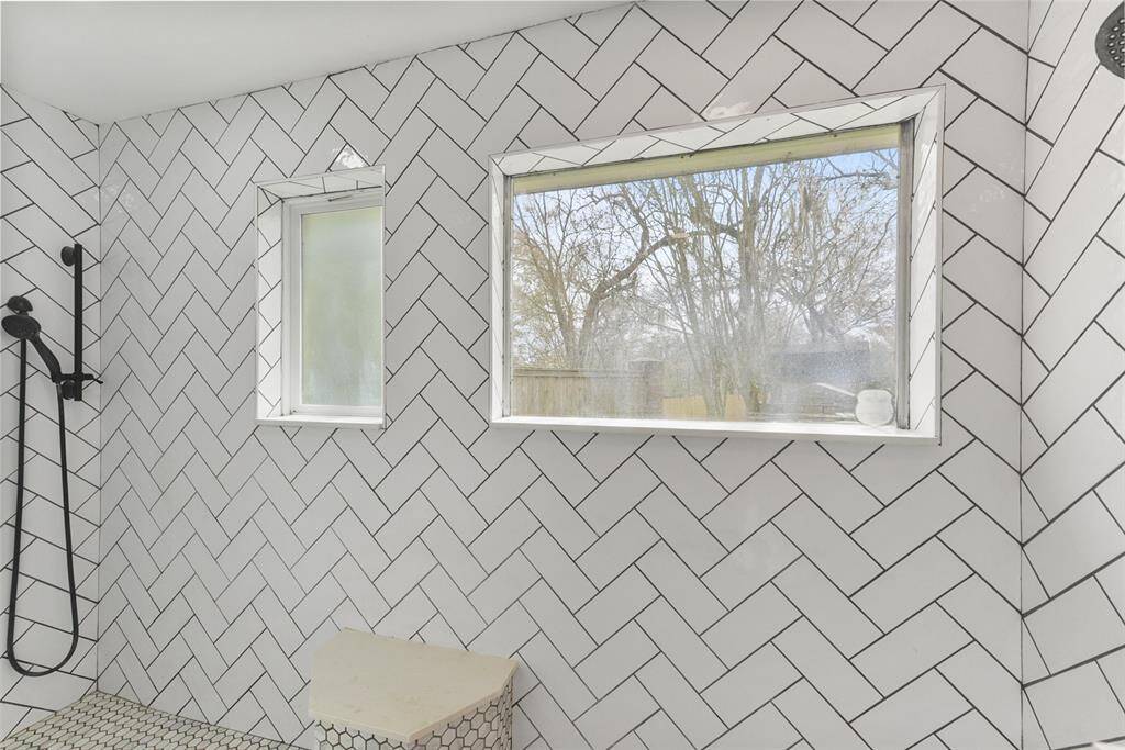 The master shower is a sight to behold, boasting a seamless glass door and detailed tilework throughout the impressively sized shower with a built-in bench seat and dual shower heads - one is a rainhead shower & the other is a removable shower head.