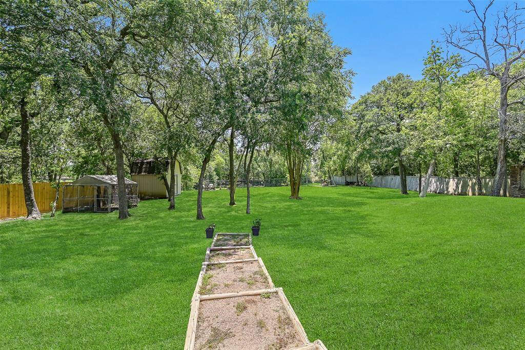 A half-panel glass door leads from the flex-use bonus room onto the lengthy covered back patio overlooking the huge 1.17-acre yard that includes a storage shed, a separate fenced pet area, and Spanish moss-draped trees sloping down to the creek bank.