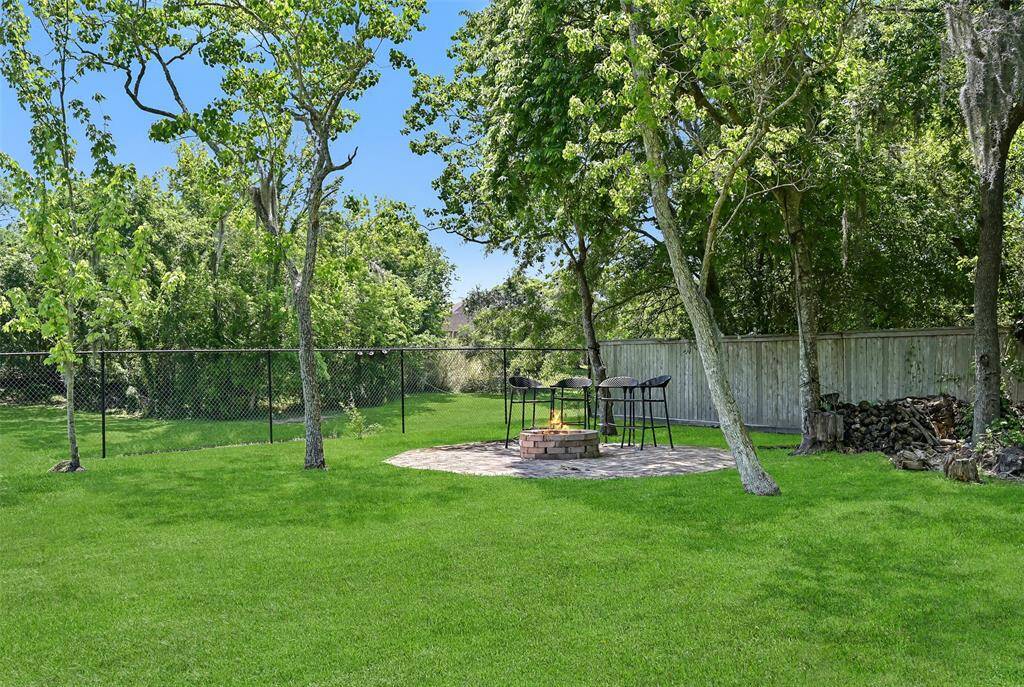 Take the gang down to the creekbank and enjoy a fireside chat around this custom-designed brick firepit area at the far end of the yard. A chain link fence with a gate allows for views of the peacefully meandering creek.
