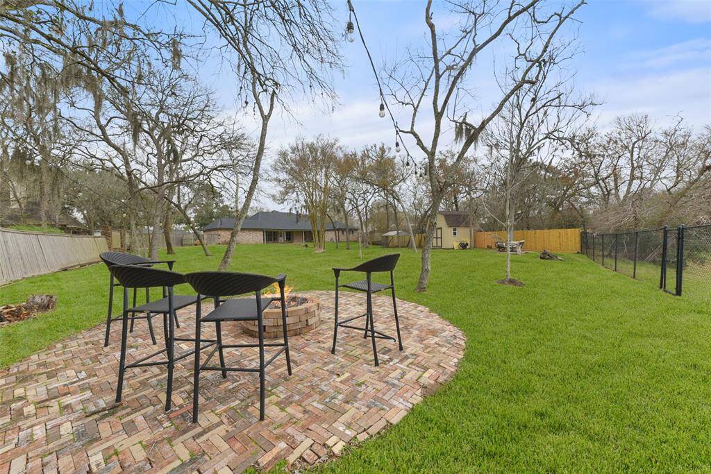 Take the gang down to the creekbank and enjoy a fireside chat around this custom-designed brick firepit area at the far end of the yard. A chain link fence with a gate allows for views of the peacefully meandering creek.