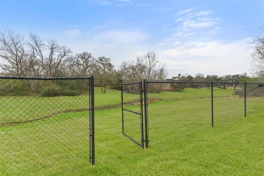 A chain-link fence with a gate keeps unwanted visitors out, while allowing both access and views of this untained paradise. It's your own private creekside oasis, and this home has NEVER flooded!