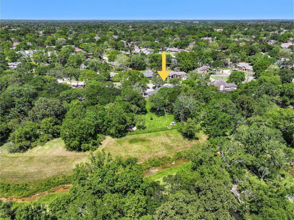 One last aerial view of this fantastic property highlights the extra large 1.17-acre creekfront lot with mature trees, a lush landscape, and the meanering creek behind the home. Also note the new roof, ample parking, and close proximity to FM 528 and Sunsaet Drive!