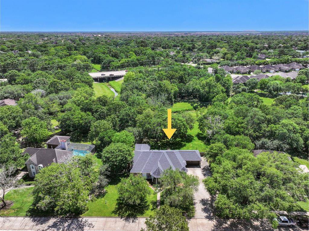 One last aerial view of this fantastic property highlights the extra large 1.17-acre creekfront lot with mature trees, a lush landscape, and the meanering creek behind the home. Also note the new roof, ample parking, and close proximity to FM 528 and Sunsaet Drive!