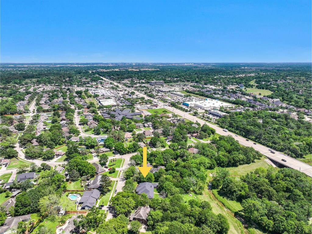 One last aerial view of this fantastic property highlights the extra large 1.17-acre creekfront lot with mature trees, a lush landscape, and the meanering creek behind the home. Also note the new roof, ample parking, and close proximity to FM 528 and Sunsaet Drive!
