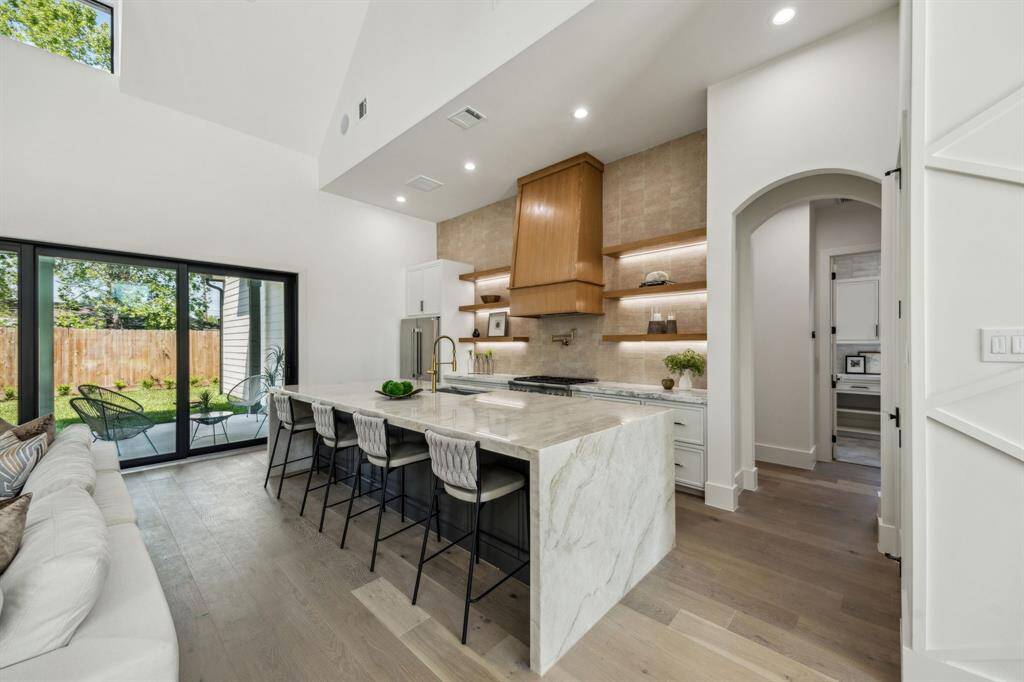 The ample kitchen island features waterfalled quartzite countertops.