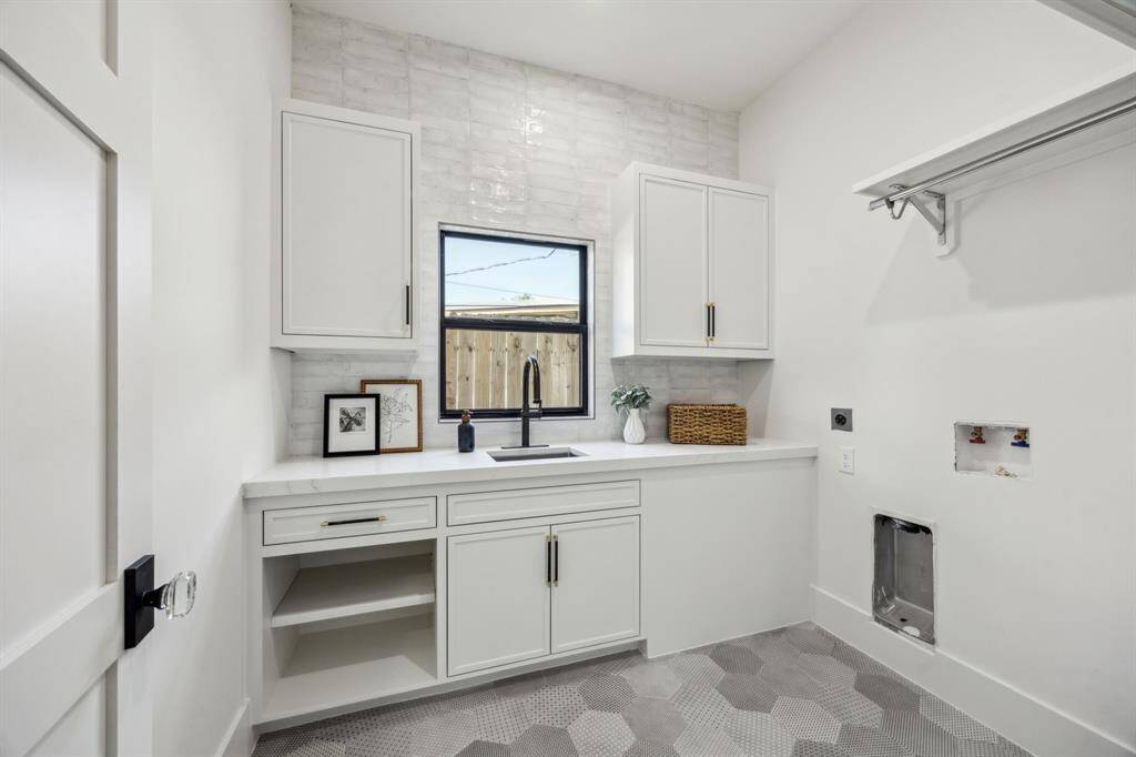 The utility room features built-in cabinets, a full sunk and a fully tiled wall. And those floor tiles sure are fun!