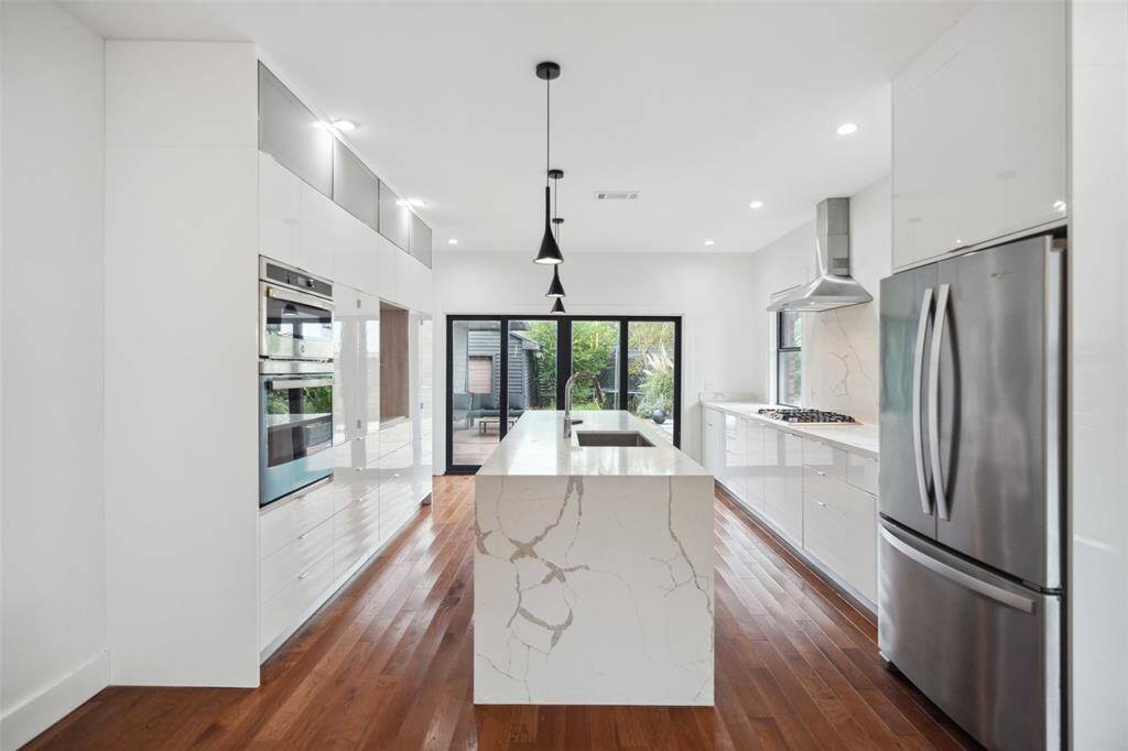 Sleek and updated, this galley kitchen has great views of the outdoor living space.