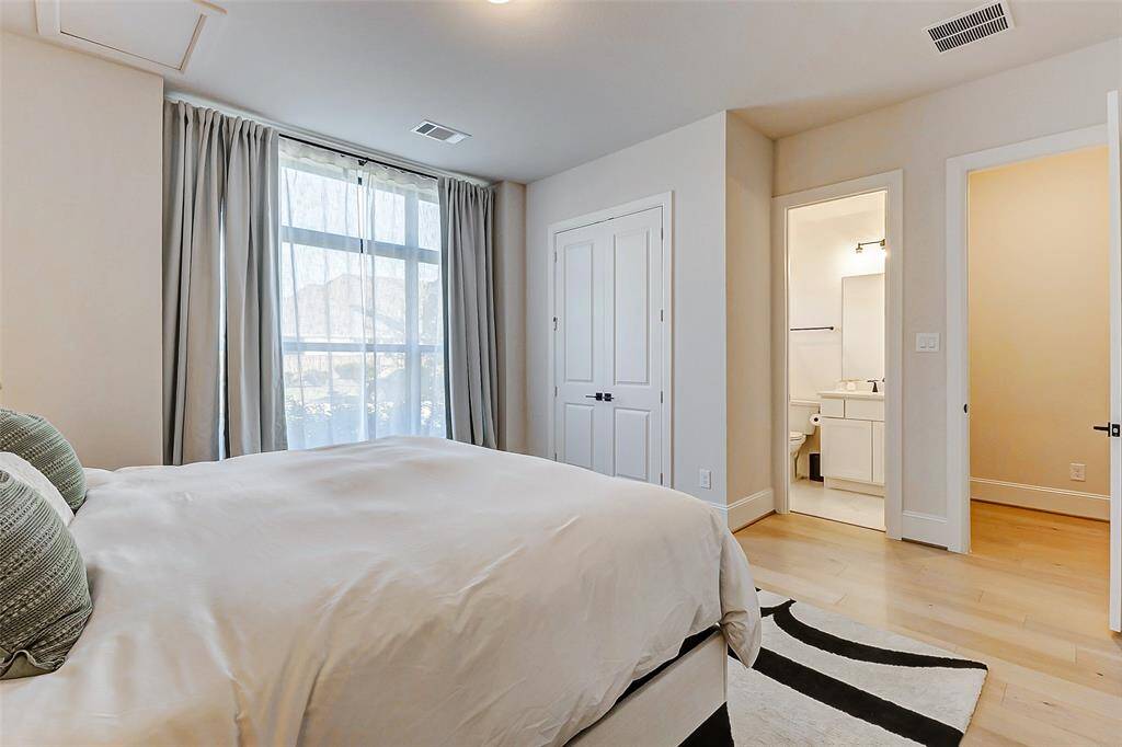 An alternate view of this guest room reveals a convenient reach-in closet and an ensuite bathroom, adding both privacy and comfort. This versatile space is ideal for guests or could easily serve as a private in-law suite.