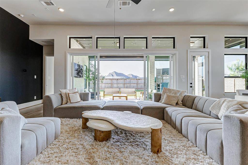 Slide open the wide glass doors to effortlessly access the expansive backyard, seamlessly extending your living space and enhancing the home’s natural indoor-outdoor flow.