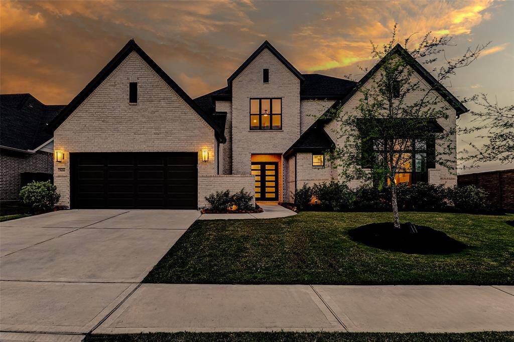 The extended double-wide driveway leads to a spacious three-car tandem garage, beautifully accented by elegant coach lights. Thoughtfully equipped with two EV chargers, this space seamlessly blends function and sophistication.